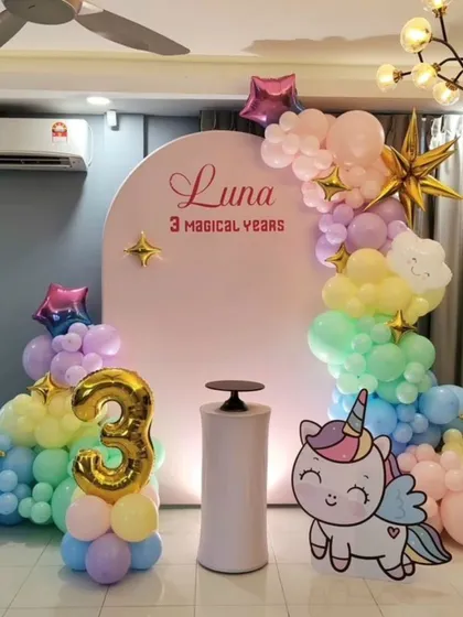 Celebrating "3 magical years" with a pastel rainbow and unicorn theme, complete with a large foil number 3 balloon and star accents.