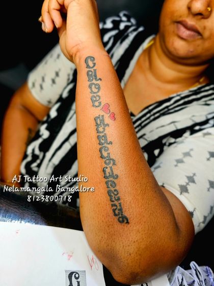 A beautiful Kannada script tattoo running down the forearm, dedicated to loved ones.
