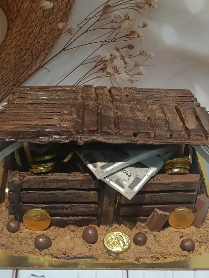 A treasure chest cake overflowing with edible gold coins and money. This creation is made almost entirely of chocolate and is perfect for a pirate-themed party or for someone who is a true treasure.