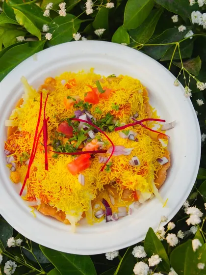 A plate of classic Papdi Chaat, generously topped with sev, chopped onions, and tomatoes. I can make it as spicy or mild as your guests prefer.