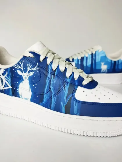 A full view of the Patronus side of the Harry Potter sneakers. The shades of blue create a mystical, nighttime forest atmosphere, with the white stag glowing brightly.