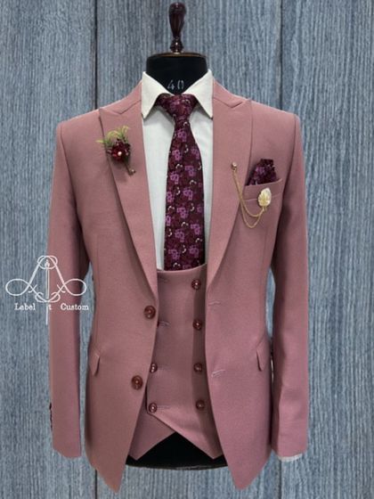 A dusty rose three-piece suit that challenges traditional formal wear. Paired with a floral tie, this is a confident and stylish choice for a daytime wedding or a special event where you want to stand out.