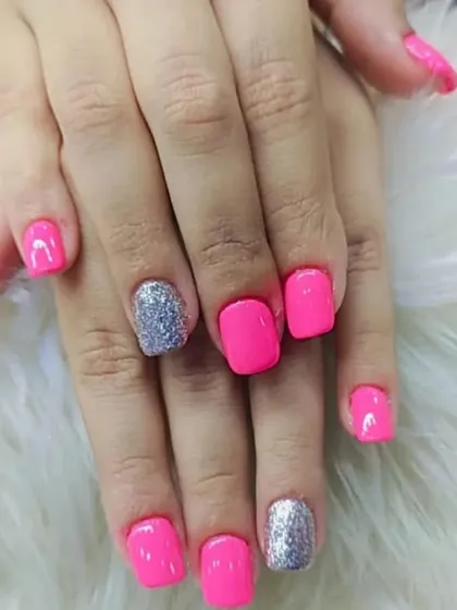 This manicure combines a bright, hot pink polish with a sparkling silver glitter accent nail. It's a fun and glamorous look that is perfect for parties or when you just want to shine.