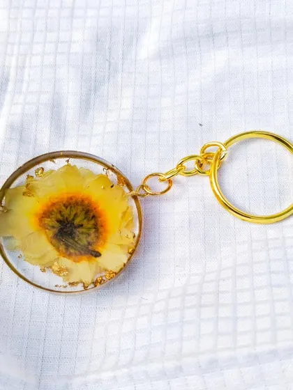 A top down view of the preserved flower keychain, showing the full bloom captured inside.