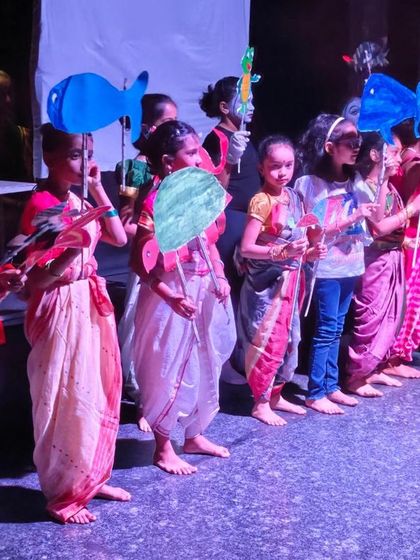 A closer look at the children with their colorful, self-made puppets. This activity combines arts and crafts with performance, giving them ownership over their theatrical creation.