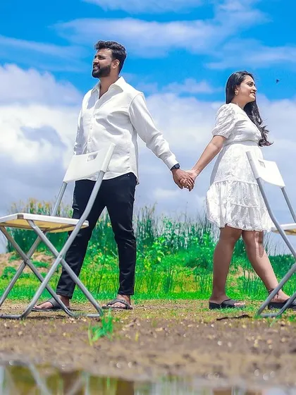 An artistic outdoor shot for a pregnancy announcement, with the couple holding hands against a beautiful sky, ready for their new chapter.