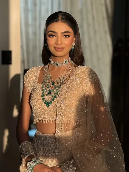 A beautiful portrait showcasing a full sangeet glam look. The eyes are the focus, with a soft shimmer that catches the light perfectly.