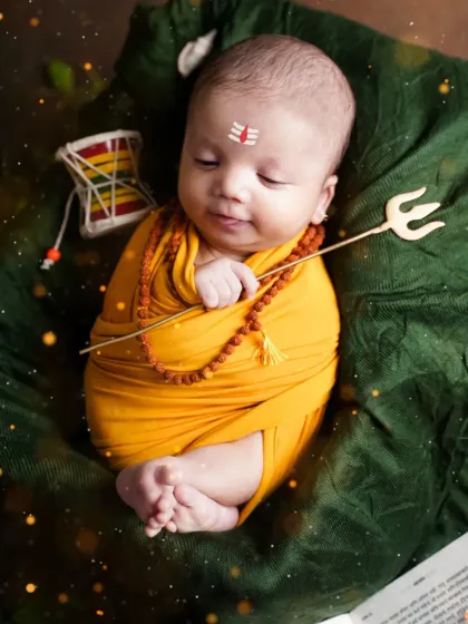 A sleeping newborn as Mahadev, holding his trishul. The peacefulness of this pose adds to the divine feel of the portrait.