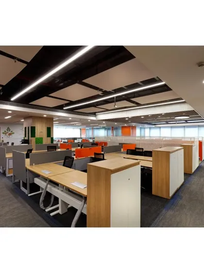 A wide shot of the workstation area, showing the modular furniture system and low storage units that double as space dividers. The layout is designed for efficiency and easy navigation across the large floor plate.