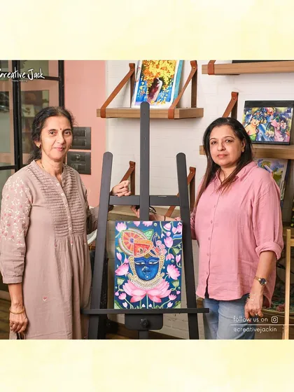 A student and I stand beside her beautiful, intricate painting of a deity, a piece she completed with dedicated effort in my fine art class.