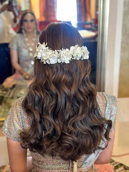 The back view showcases the beautiful floral crown and the soft, flowing waves.