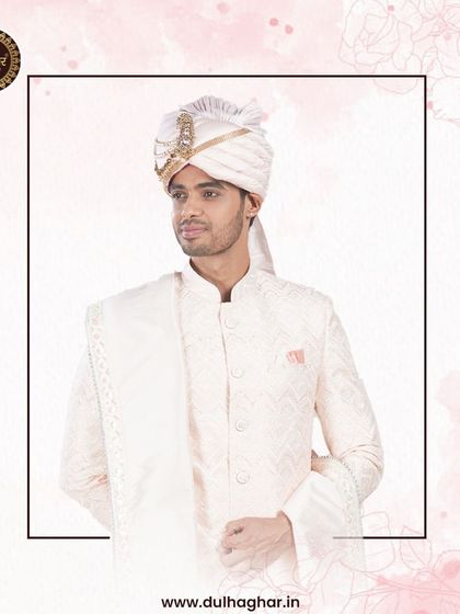 A regal look in a white sherwani, showcasing the complete ensemble with a matching safa.
