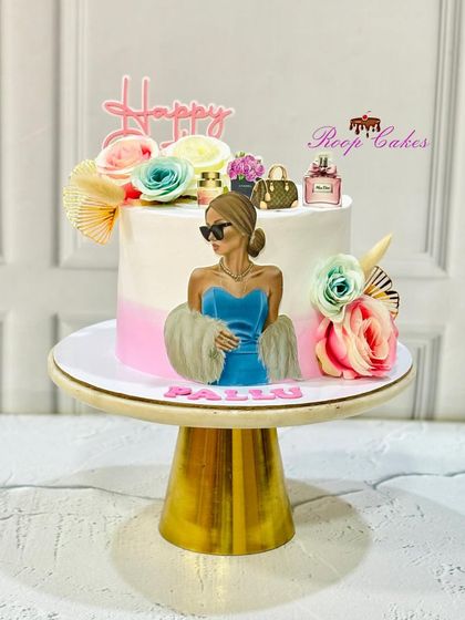 A stylish cake for a fashion lover. This design features an illustration of a chic woman, surrounded by flowers and edible miniatures of perfume bottles and designer bags.