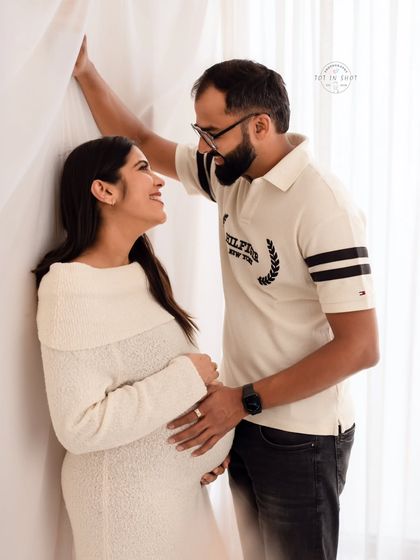 A sweet, loving gaze between a couple in cozy knitwear, captured in a bright, high-key lighting setup.