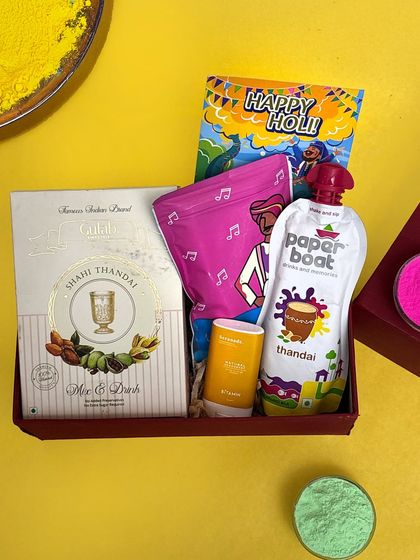 A close-up of another one of my affordable Holi hampers. This one includes Shahi Thandai mix, a packet of gulal, a pouch of Paper Boat thandai, and a small jar of Chandan tika.