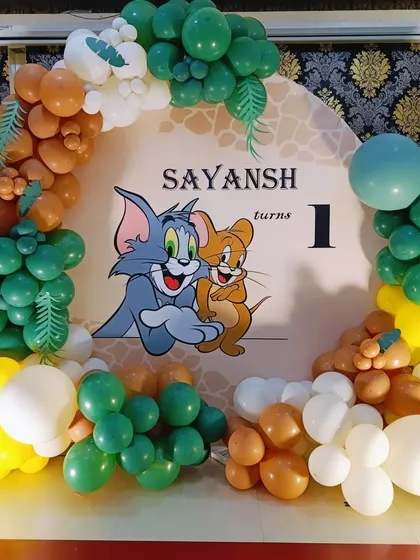 Another shot of the Tom and Jerry balloon arch against the themed backdrop.