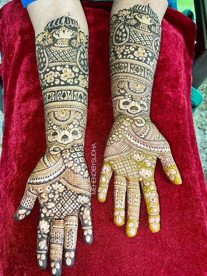 A classic bridal design for Divya, featuring bride and groom figures on the forearms, surrounded by delicate floral and paisley patterns.