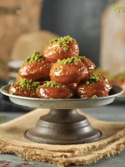 These traditional Indian sweets, similar to Balushahi, are soaked in sugar syrup and garnished with pistachios. They are a perfect, bite-sized treat to include in a classic mithai spread.
