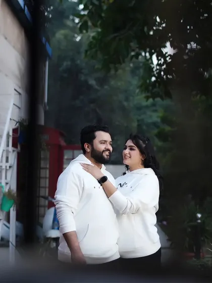 A candid and cozy portrait of a couple in matching white hoodies. This shot captures a simple, sweet moment of togetherness.