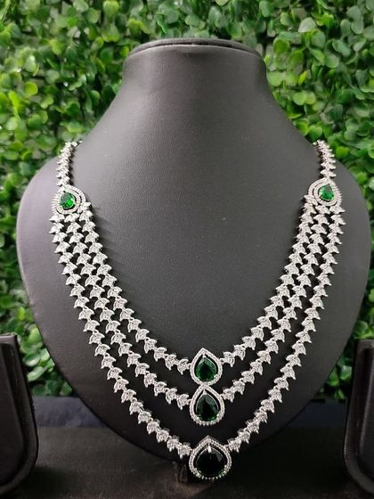 A dramatic, multi-layered American Diamond necklace with emerald-green stones. This is a true showstopper piece available for rent.