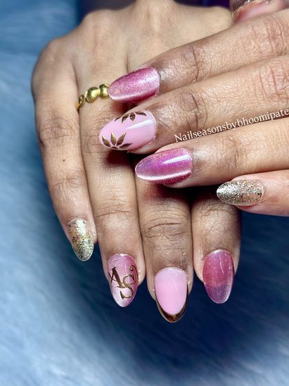 This set has it all: pink cat eye, gold glitter, chrome tips, and custom initials. It’s a perfect example of how we can combine different trends into one design.