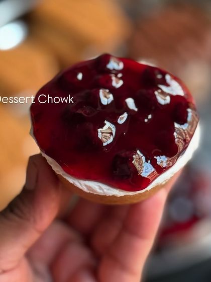 A mini cheesecake topped with a shiny berry compote and decorated with edible silver leaf. These little bites are both elegant and delicious.
