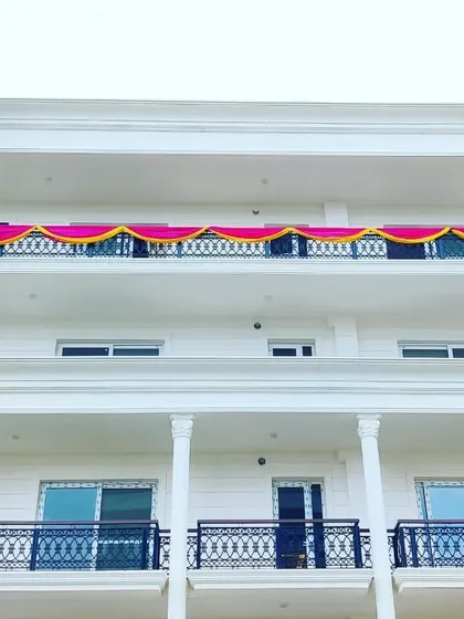 We also handle exterior decorations for your housewarming. Here, we've added simple yet festive fabric draping in pink and yellow along the balcony railing to mark the celebration.