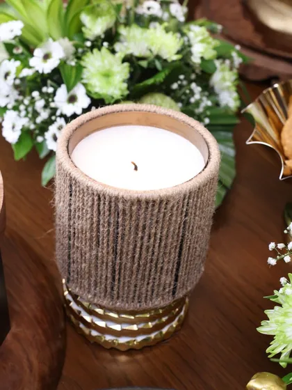 A close-up of our jute-wrapped scented candle, a piece that brings a touch of rustic texture and warm light to any setting. It’s a simple detail that creates instant peace.