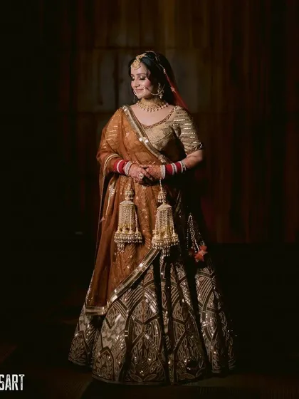 A golden, glowing Sikh bride. This dramatic portrait captures the regal feel of her look, with a heavy focus on bronzed, shimmering makeup.