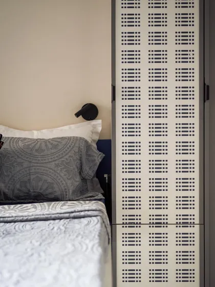 A detail of the custom Murphy bed and wardrobe unit. The perforated panel adds a graphic element and provides ventilation.