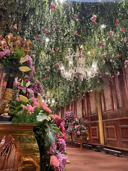 Another angle of the enchanting floral entranceway. The combination of rich wood-paneled walls, a lush green ceiling, and abundant fresh flowers creates an unforgettable first impression.