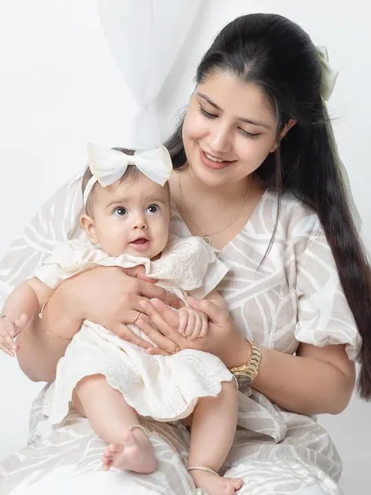 A sweet and gentle moment between a mother and her baby girl. The soft lighting enhances the tender mood.