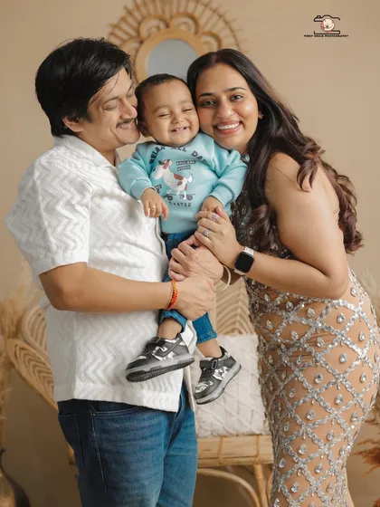 The perfect family hug, full of laughter and warmth. This is a classic family portrait from a studio session, showing the beautiful bond between parents and their child. It’s a timeless, frame-worthy memory of pure happiness.