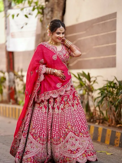 The timeless charm of a bride in red. Her flawless base, soft flushed cheeks, and a subtle hint of shimmer on the lids create a timeless glow.