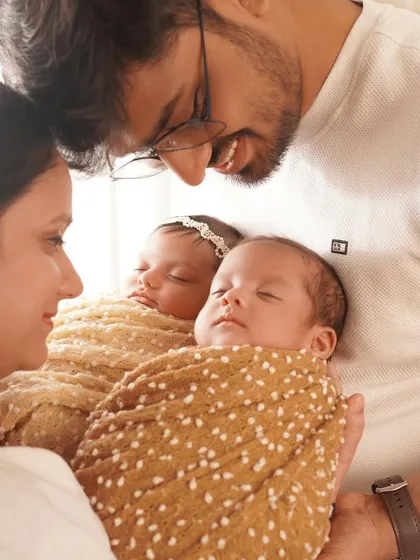 A close-up of the parents' faces as they lovingly gaze at their newborn twins. This shot is all about the deep connection and overwhelming love of a new family.