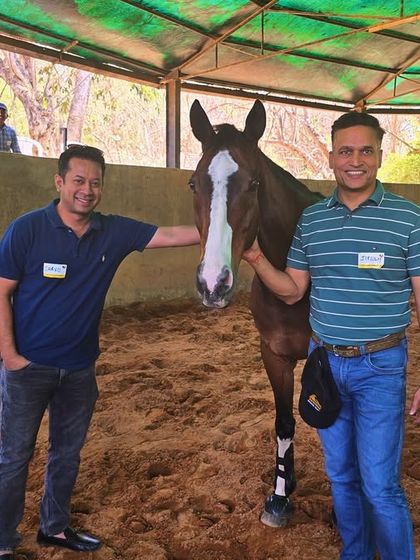 Two participants in our Horse Leadership Program pose with their equine partner in our covered arena. These sessions provide immediate, honest feedback that is invaluable for personal and professional growth.