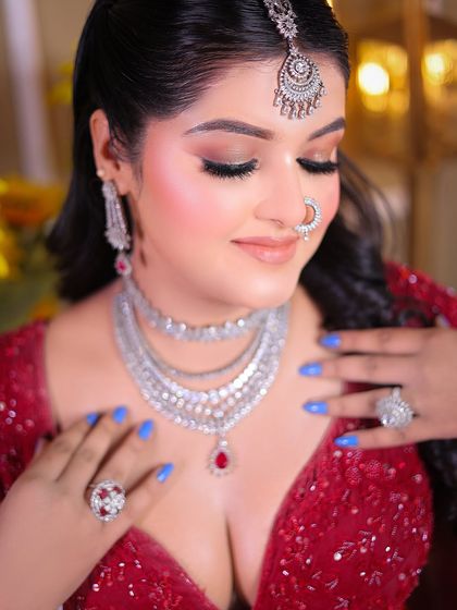 A close-up beauty shot focusing on the bride's silver jewelry and elegant makeup.