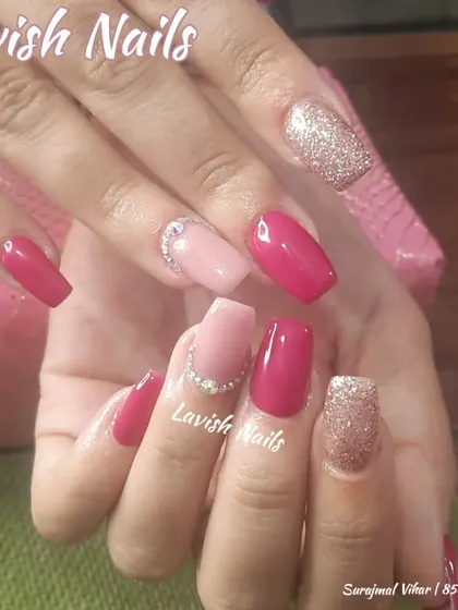 A fun and bright set with pink, glitter, and rhinestone accents on square nails.