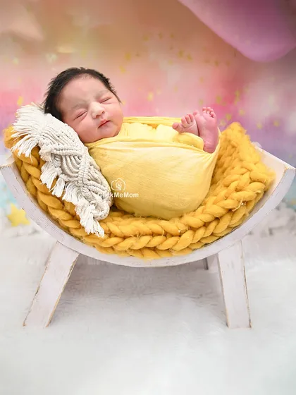 A similar setup with a slightly different angle, this image captures the peaceful sleep of a newborn in a warm and colorful setting.