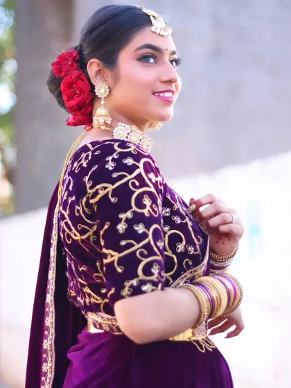 A side view of the reception look, showing the beautiful rose bun and embroidered blouse.