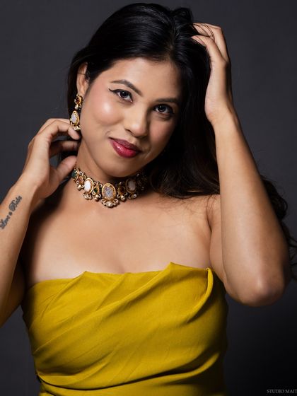 A relaxed and happy portrait of the model in the yellow top.
