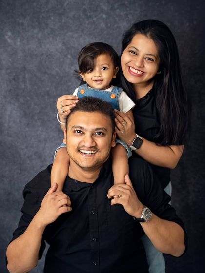 A fun and playful family pose with a toddler enjoying a shoulder ride. We love incorporating action and play into our sessions to capture your family's dynamic energy.