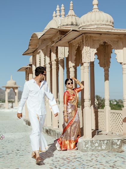 A dynamic shot of the couple walking along the beautiful corridors of a palace in Pushkar. The architecture creates leading lines that draw the eye, adding depth to this royal pre-wedding photo.