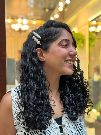 I had so much fun styling this real-life Moana. Her beautiful, long curls are accessorized with flowers and clips, showing how versatile curly hair can be.