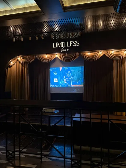 The stage and screening setup at Limitless Luxe, highlighting the venue's potential for live events and entertainment during a dine-in experience.