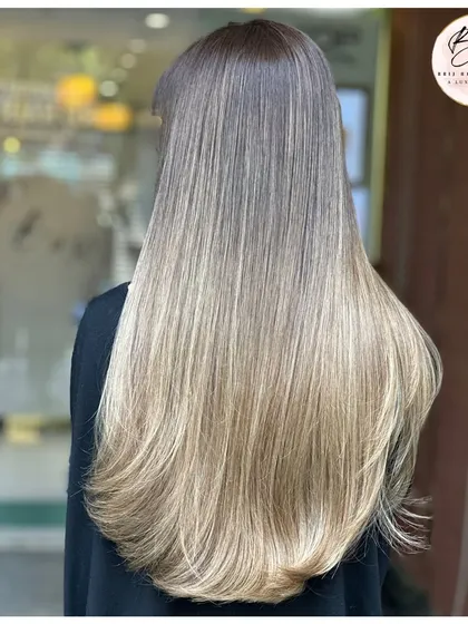 A perfect example of a sun-kissed, modern balayage. The way these light, creamy tones cascade down from the darker roots creates a beautiful, low-maintenance gradient. This is the kind of effortless elegance that looks stunning whether your hair is straight or styled in waves.