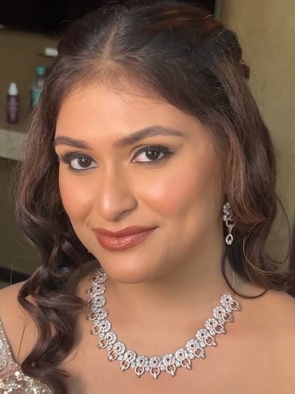 A close-up of the clean Sangeet glam. The focus is on a flawless base, a soft brown smokey eye, and a glossy nude lip.