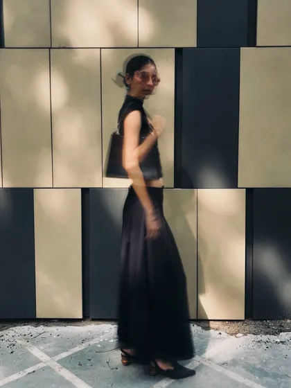 A blurry, motion-filled shot of an all-black outfit. This captures the energy and movement of city life and street style.
