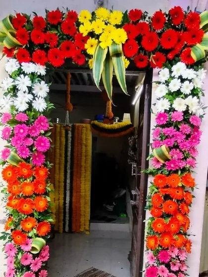 A very vibrant door frame made with columns of colorful gerbera daisies. This rainbow-like effect is eye-catching and creates a joyful and high-energy welcome for any special occasion.