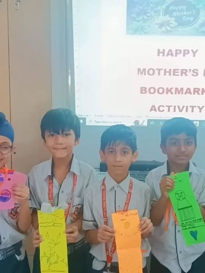 Students proudly display the colorful bookmarks they created for Mother's Day. This craft activity combines artistic expression with a practical gift, encouraging thoughtfulness and creativity.